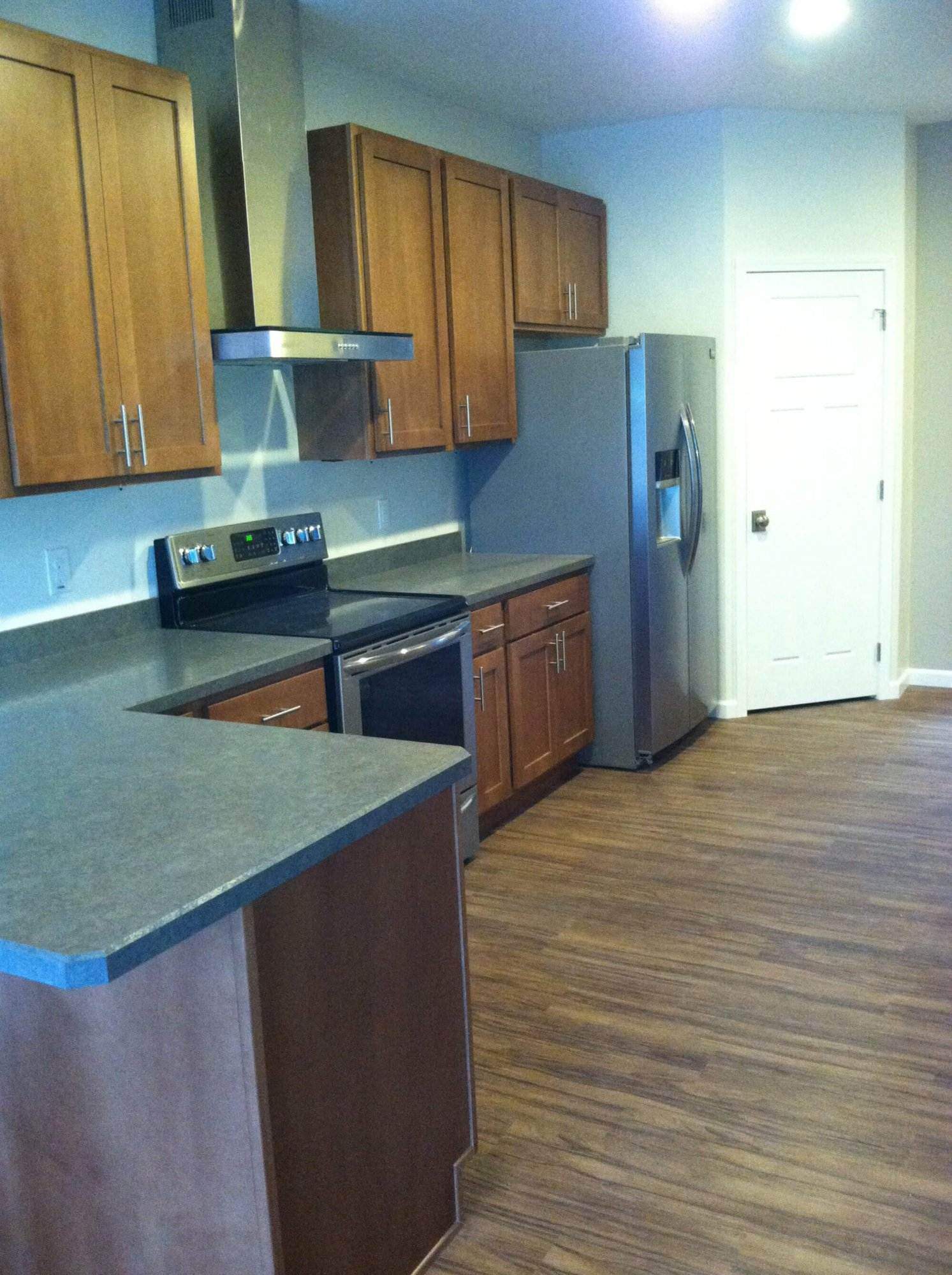 A new kitchen with a stove and refrigerator in a home building.
