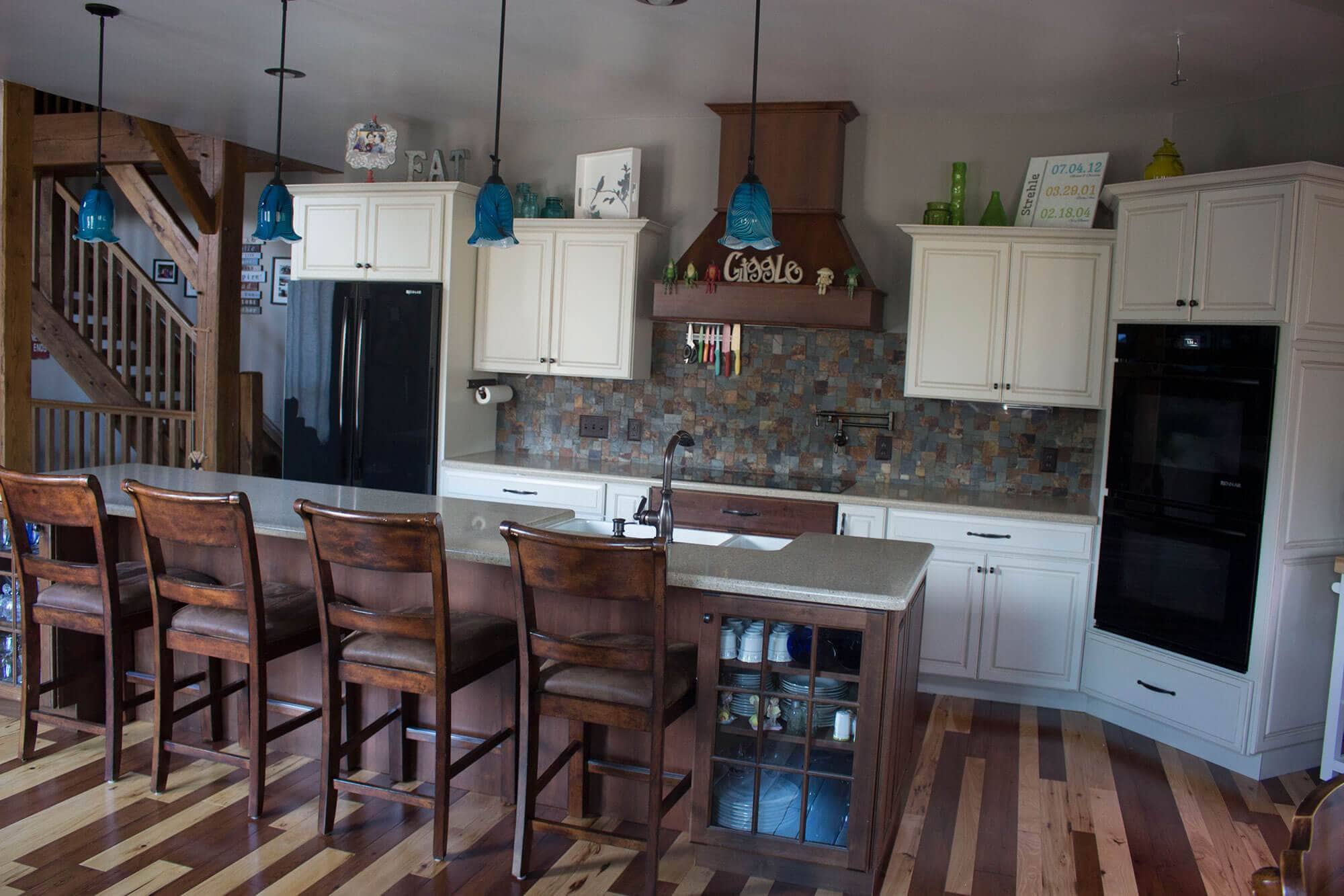 A new kitchen with wood floors and bar stools.