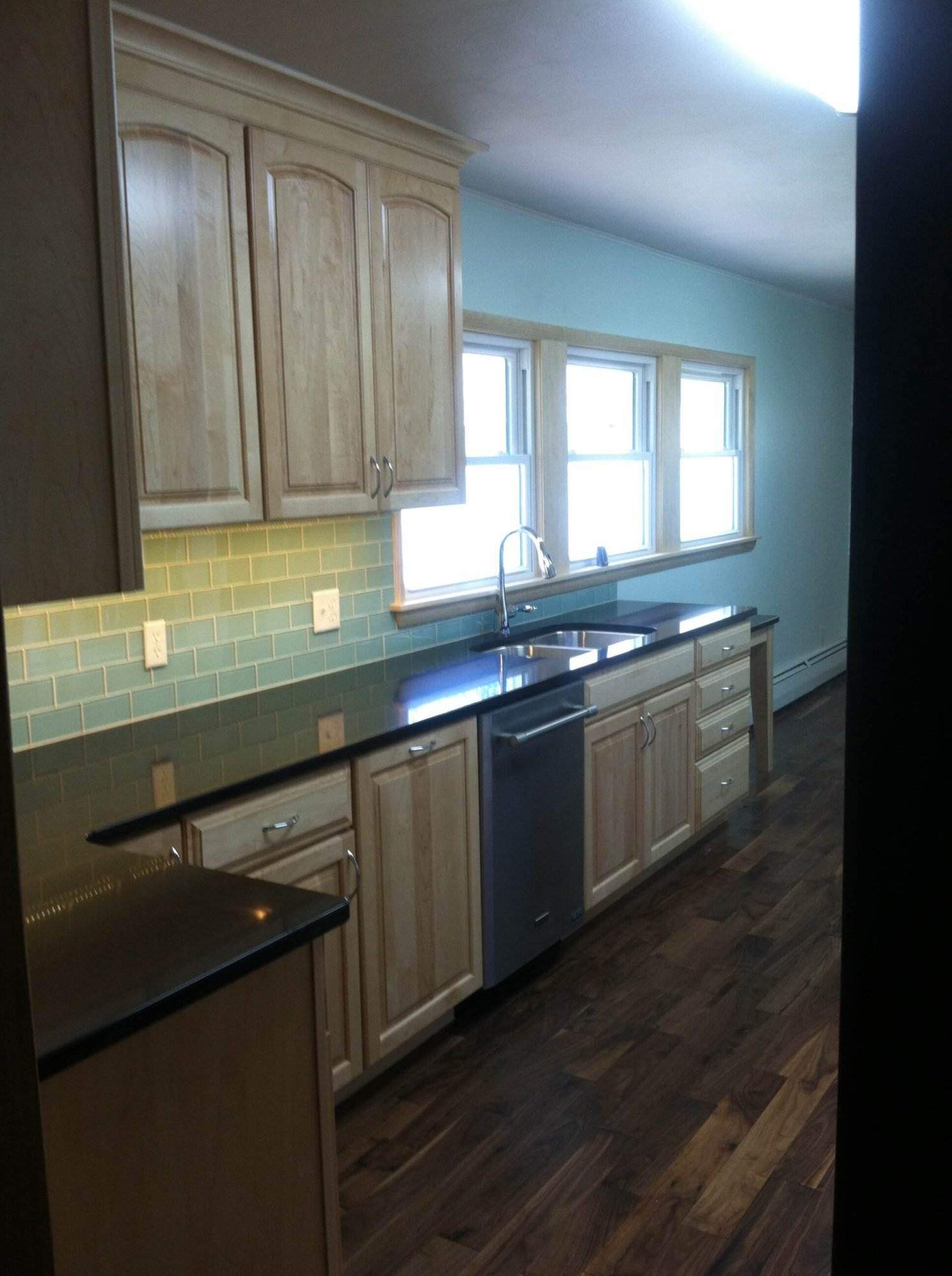 Kitchen remodeling: A kitchen with a sink and a refrigerator has been elegantly renovated to enhance functionality and aesthetic appeal.