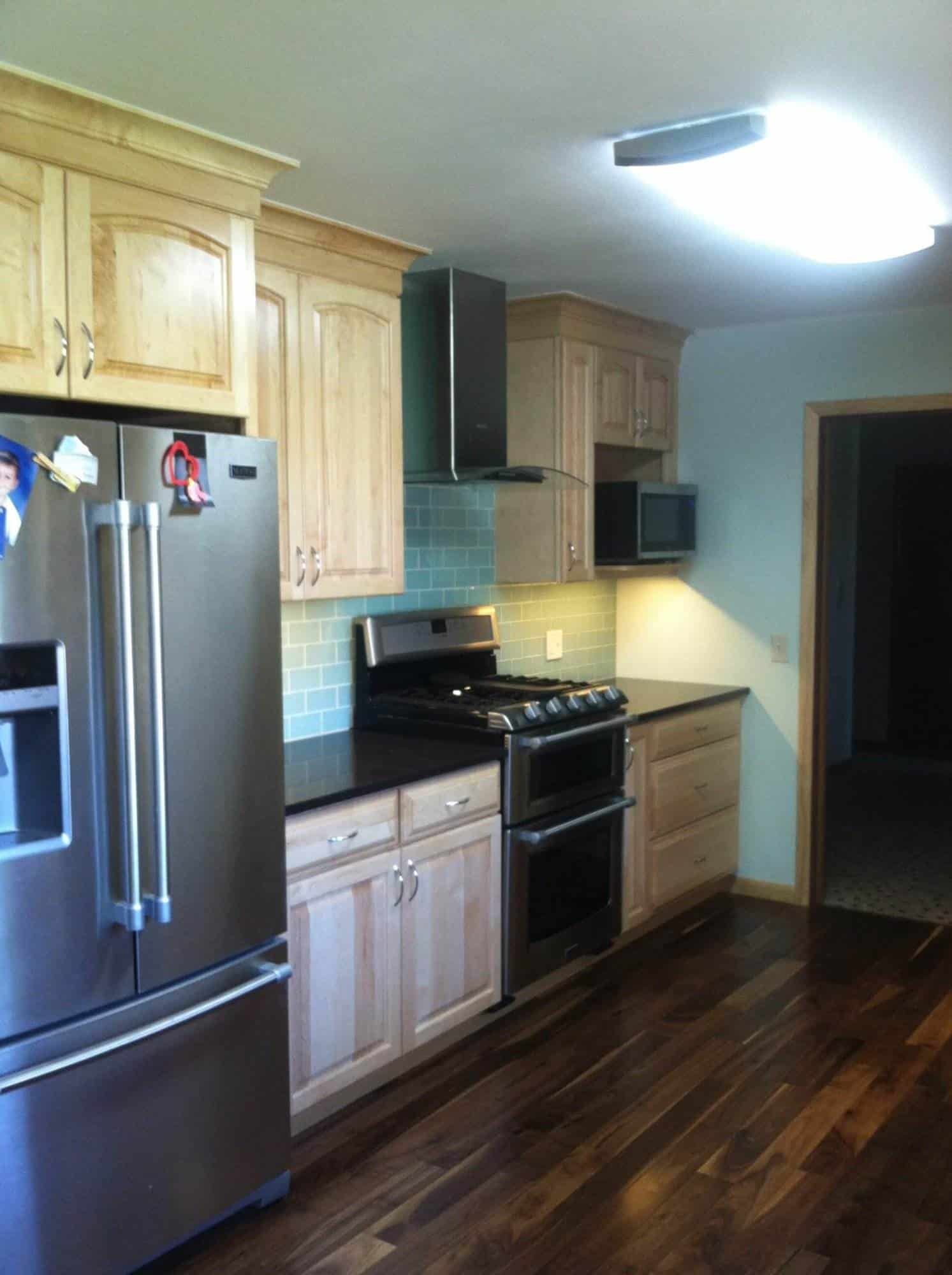 A kitchen with stainless steel appliances and hardwood floors, perfect for kitchen remodeling.