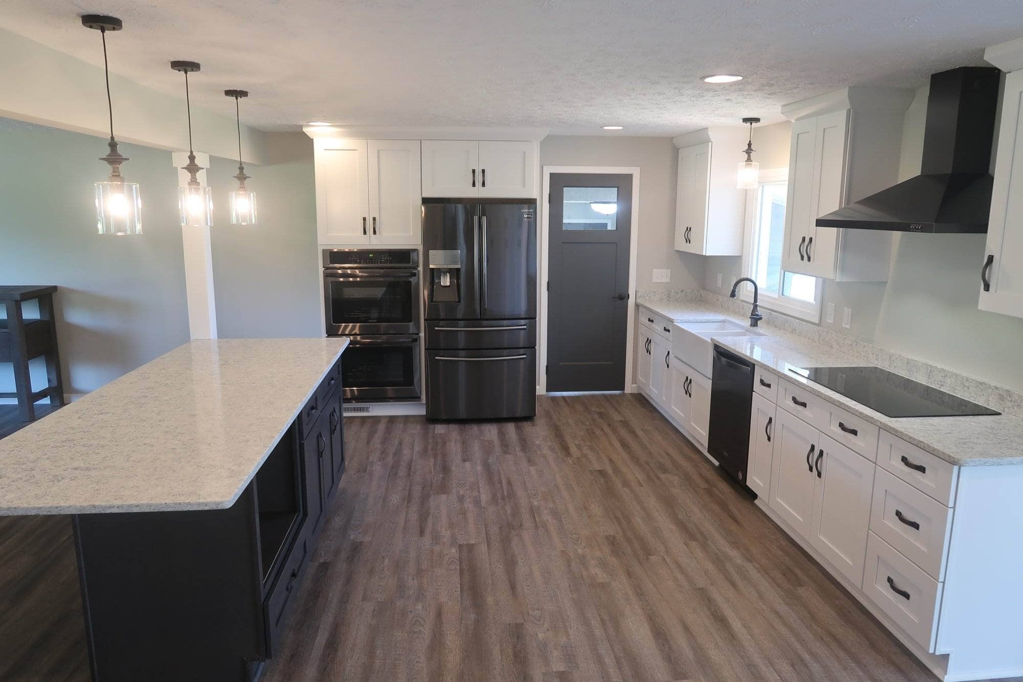 A kitchen undergoing remodeling with white cabinets and black appliances.