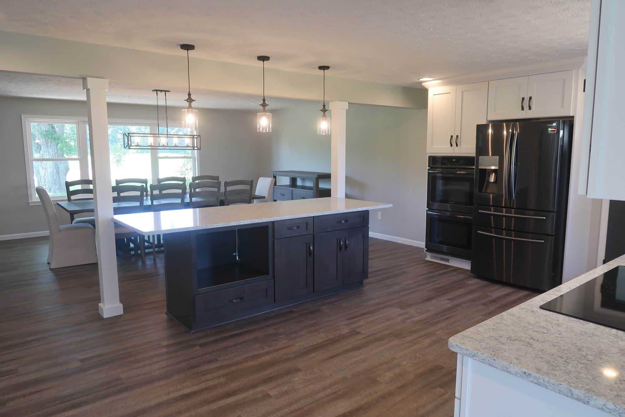 A kitchen with white cabinets and black appliances.