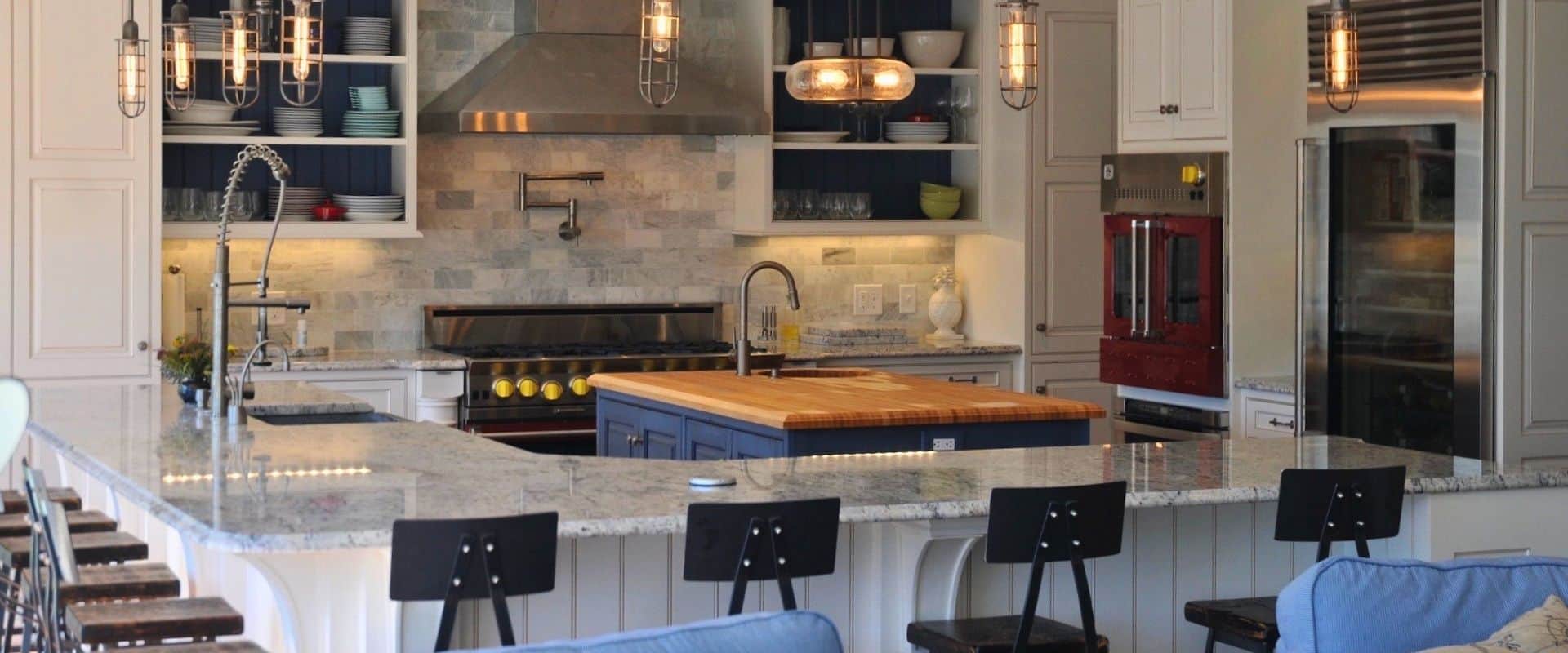 A kitchen with a large island and blue chairs.