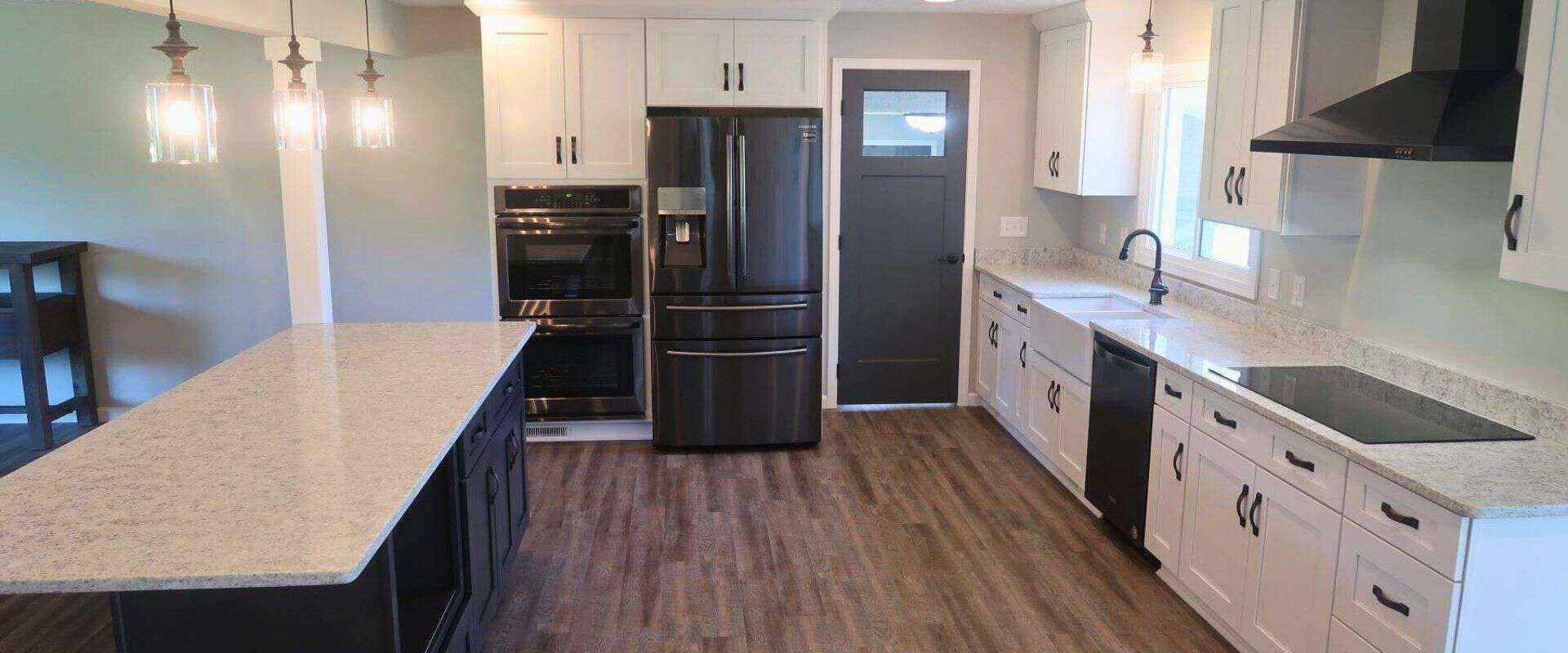 A kitchen with white cabinets and black appliances.